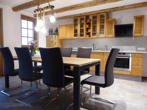 a kitchen with a wooden table and chairs at Fischerhof in Höchenschwand
