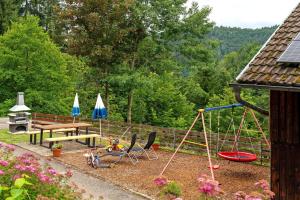 a playground with a picnic table and a swing at Ferienhof Brutoni in Bad Peterstal-Griesbach