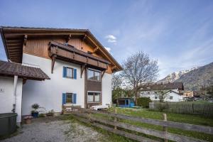 a house with a wooden roof and a fence at Haus Bergliebe in Pfronten