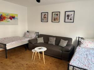 ein Wohnzimmer mit einer Couch und zwei Betten in der Unterkunft Wohnung Weida in Riesa