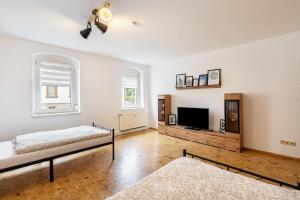 ein Schlafzimmer mit zwei Betten und einem Flachbildfernseher in der Unterkunft Wohnung Weida in Riesa