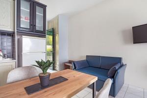 a living room with a table and a blue couch at Sunset Premium Studio 7 in Lefkada