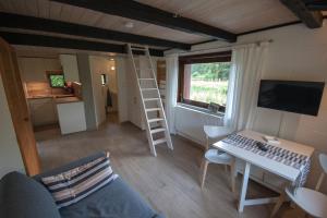 a living room with a desk and a computer and a ladder at Blockhaus Quellental in Odderade +17 photos