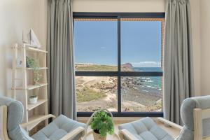 a living room with a large window with a view of the ocean at Maresía in Los Abrigos