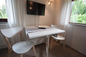 a room with a white table and chairs and a tv at Blockhaus Quellental in Odderade