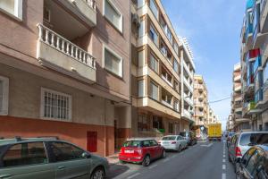 a street with cars parked on the sides of buildings at Almdna15-atc in Torrevieja