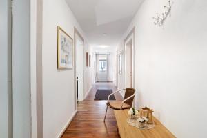 a hallway with white walls and a chair and a table at Ferienwohnungen Roth in Willingen +33 photos
