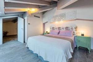 a bedroom with a large bed with purple pillows at Abaye 5 Barolo - Charm Adults Only in Soiano del Lago +22 photos
