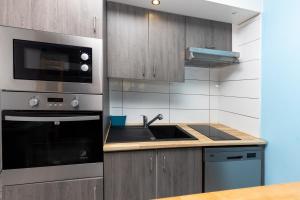 a kitchen with a sink and a microwave at Location Seignosse Le Penon in Seignosse
