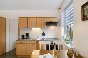 a kitchen with wooden cabinets and a wooden table at Ferienwohnungen Schmitz in Wangerland