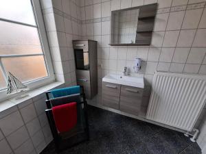 a bathroom with a sink and a mirror at Ferienwohnungen Schmitz in Wangerland +41 photos