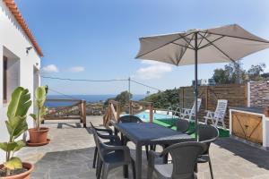 a patio with a table and chairs and an umbrella at Los Barranquillos in Las Palmas de Gran Canaria