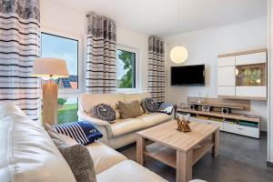 a living room with a couch and a table at Ferienvilla Kapitänshaus in Karlshagen