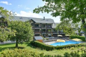 an exterior view of the inn with a swimming pool at L’ourson in Les Déserts