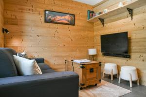 a living room with a couch and a flat screen tv at L’ourson in Les Déserts