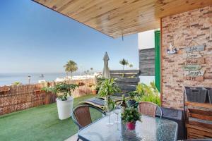 a patio with a table and chairs and the ocean at Sunset Apartment in Puerto Rico de Gran Canaria