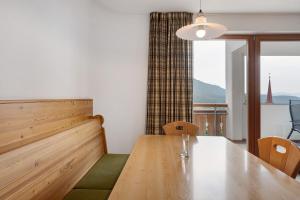 a dining room with a table and a large window at Residence Nussbaumer in Siusi