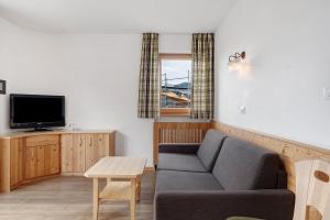 a living room with a couch and a tv at Residence Nussbaumer in Siusi