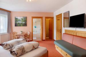 a bedroom with two beds and a flat screen tv at Ferienwohnung Piburgersee in Oetz