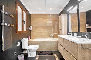 a bathroom with a toilet and a tub and a sink at Somni in Jávea +16 photos