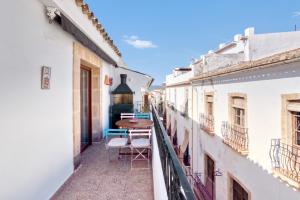 a balcony with a table and chairs in an alley at Somni in Jávea