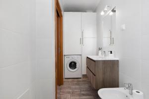 a bathroom with a washing machine and a sink at Casa Do Alto in Tavira +14 photos