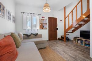a living room with a couch and a staircase at Casa Do Alto in Tavira