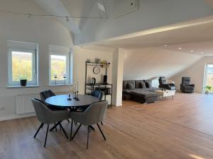 a living room with a table and chairs and a couch at Ferienwohnung Waldblick Alterkülz in Alterkülz