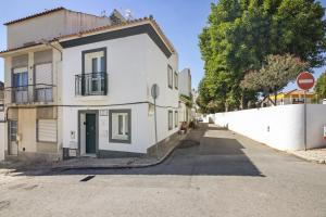 a white house on the side of a street at Casa Do Alto in Tavira