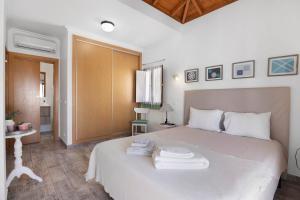 a bedroom with a white bed with towels on it at Casa Do Alto in Tavira