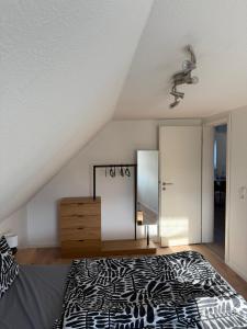 a bedroom with a black and white bed and a mirror at Ferienwohnung Waldblick Alterkülz in Alterkülz