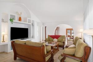 a living room with a couch and a tv at Villa Muñoz in Puerto del Carmen