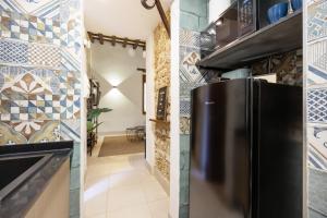 a kitchen with a black refrigerator and tile walls at Bella Encantada in Cádiz +16 photos