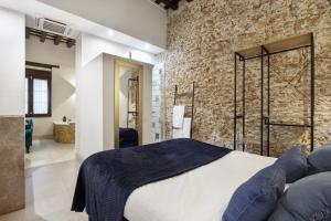 a bedroom with a bed and a brick wall at Bella Encantada in Cádiz