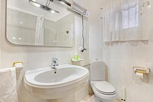 a white bathroom with a sink and a toilet at Cal Guerrer in Mogente