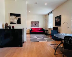 a living room with a red couch and a table at Vorwerk Biensdorf in Lichtenau