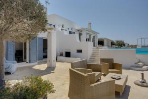 a view of a villa with chairs and a table at Blueros - Olive suite in Megas Gialos - Nites