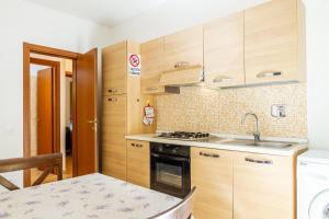 a kitchen with wooden cabinets and a sink and a table at Acqua in Follonica
