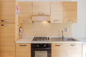 a kitchen with wooden cabinets and a stove top oven at Acqua in Follonica