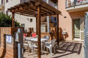 a wooden pergola with a table and chairs on a patio at Acqua in Follonica