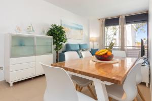 a dining room with a wooden table and white cabinets at Mar i Llum in Platja d'Aro