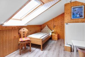 a room with a bed and a chair in a attic at Landferien Schütt in Neuenkirchen
