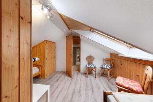 a attic room with two chairs and a staircase at Landferien Schütt in Neuenkirchen