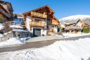 a log home in the snow with a garage at Chalet au bois joli in Valloire