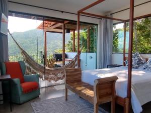 a bedroom with a hammock and a room with a view at Segunda Casa-CASA DE TEMPORADA in Paraty