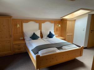 a bedroom with a large wooden bed with blue pillows at Apartment Bergglück Wildschönau in Wildschönau