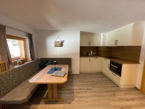 a small kitchen with a wooden table and a couch at Apartment Bergglück Wildschönau in Wildschönau