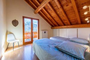 a bedroom with a bed and a wooden ceiling at Chalet au bois joli in Valloire