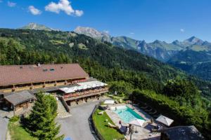 an aerial view of a resort with a pool and mountains at Chalet Karavi in Manigod
