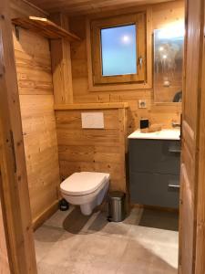 a wooden bathroom with a toilet and a sink at Chalet Karavi in Manigod +7 photos